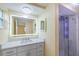 Updated bathroom features a modern vanity, backlit mirror, and tiled shower with glass door at 5102 Peacock, Holiday, FL 34690