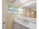 Updated bathroom has a modern sink, illuminated mirror, and window for natural light at 5102 Peacock, Holiday, FL 34690