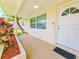 Inviting front porch with a well-maintained garden bed and a white front door with half moon window design at 5102 Peacock, Holiday, FL 34690