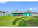 Spacious backyard features a screened in patio and lush green lawn under a clear blue sky at 5107 Pine St, Seffner, FL 33584