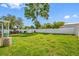 Large backyard with a shed, large tree, lush green grass, and white fence at 5107 Pine St, Seffner, FL 33584
