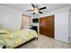 Cozy bedroom with ceiling fan, mounted tv, tan tiled floor, and large closet for optimal storage at 5107 Pine St, Seffner, FL 33584