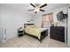 Bright bedroom featuring a full bed, a ceiling fan, tiled floor, and a window for natural lighting at 5107 Pine St, Seffner, FL 33584
