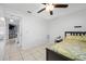 Comfortable bedroom with neutral colors, a ceiling fan, tiled floors, and adjacent hallway at 5107 Pine St, Seffner, FL 33584