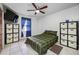 Bedroom with decorative shelving units flanking window; ceiling fan and neutral tiled floor at 5107 Pine St, Seffner, FL 33584