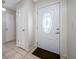Clean entryway with white doors, neutral tile flooring, and a decorative glass front door at 5107 Pine St, Seffner, FL 33584