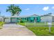Charming turquoise single-story home featuring a white picket fence and attached carport at 5107 Pine St, Seffner, FL 33584