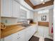Bright kitchen featuring white cabinets, wooden countertop, and a stainless steel sink at 5107 Pine St, Seffner, FL 33584