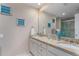 Bathroom featuring double sink vanity with granite countertop, decorative mirror, and wall art at 5340 Cobblestone Ct, Wesley Chapel, FL 33543