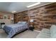 Cozy bedroom featuring a wooden accent wall, a comfortable bed and sofa at 5340 Cobblestone Ct, Wesley Chapel, FL 33543