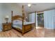 Bedroom with a four-poster bed, wood floors, and a sliding glass door with white curtains at 5340 Cobblestone Ct, Wesley Chapel, FL 33543