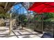 Covered, screened patio with outdoor seating, grill, red umbrella, and view of tropical foliage at 5340 Cobblestone Ct, Wesley Chapel, FL 33543