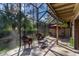 Screened patio with outdoor seating, table, umbrella and foliage creating a relaxing outdoor space at 5340 Cobblestone Ct, Wesley Chapel, FL 33543