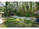 Expansive backyard with healthy green lawn, and a white fence backing to woods at 5346 Black Pine Dr, Tampa, FL 33624