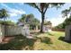 Exterior view of home shows the backyard, a large shade tree, and fenced yard at 5346 Black Pine Dr, Tampa, FL 33624