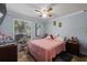 Comfortable bedroom with a pink quilt, light blue walls, wood floors, and a ceiling fan at 5346 Black Pine Dr, Tampa, FL 33624