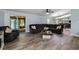Open-concept living room features a sectional sofa, wood floors, and sliding doors to the lanai at 5346 Black Pine Dr, Tampa, FL 33624