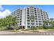 Stunning exterior view of Harbour Hill, featuring balconies, lush landscaping, and direct street access at 700 Beach Ne Dr # 606, St Petersburg, FL 33701