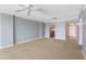 The living room features neutral carpet, a ceiling fan, a kitchen doorway, and an entry doorway at 700 Beach Ne Dr # 606, St Petersburg, FL 33701