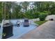 Back deck with grill, chair, and chaise lounge, perfect for outdoor relaxation and entertaining overlooking the lush backyard at 7010 Kendall Heath Way, Land O Lakes, FL 34637