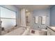 A well-lit bathroom showcases a soaking tub and tiled walls at 7010 Kendall Heath Way, Land O Lakes, FL 34637