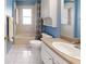 A brightly lit bathroom featuring tiled floors and blue walls at 7010 Kendall Heath Way, Land O Lakes, FL 34637