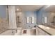 A well-lit bathroom features granite counters and tiled shower at 7010 Kendall Heath Way, Land O Lakes, FL 34637