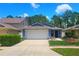 Charming single-story home with a well-maintained lawn, lush landscaping, and two car garage at 7010 Kendall Heath Way, Land O Lakes, FL 34637