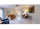 Open-concept living room with high ceilings, tile floors, and a large TV at 7010 Kendall Heath Way, Land O Lakes, FL 34637
