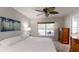 Bright main bedroom featuring a large window with a seating area and a stylish ceiling fan at 7010 Kendall Heath Way, Land O Lakes, FL 34637