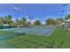 Overhead view of tennis courts with well-maintained blue playing surface and green surroundings at 7010 Kendall Heath Way, Land O Lakes, FL 34637