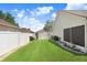 This backyard features an expansive lawn, flowerbeds, and a white fence, creating a private outdoor space at 7101 Bucks Ford Dr, Riverview, FL 33578