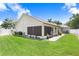 Well-maintained backyard featuring a manicured lawn, white fence, landscaping, and a patio with a grill for outdoor enjoyment at 7101 Bucks Ford Dr, Riverview, FL 33578