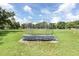Open community baseball field with blue bench seating in a green grass park under a bright blue summer sky at 7101 Bucks Ford Dr, Riverview, FL 33578