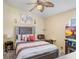 Comfortable bedroom with a decorative headboard, ceiling fan, plush bedding, and a cozy armchair at 7101 Bucks Ford Dr, Riverview, FL 33578