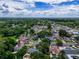 Scenic aerial perspective of a charming neighborhood with tree-lined streets under a beautiful blue sky filled with fluffy clouds at 7111 Lawnview Ct, Tampa, FL 33615