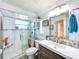 Bathroom featuring updated shower with glass door, modern vanity, and neutral tones at 7111 Lawnview Ct, Tampa, FL 33615