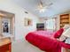 Comfortable bedroom featuring soft carpet, a TV, and a bookcase for storage and display at 7111 Lawnview Ct, Tampa, FL 33615