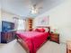 Cozy bedroom with a red comforter, ceiling fan, and TV for relaxation and entertainment at 7111 Lawnview Ct, Tampa, FL 33615