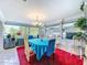 Bright dining room features a vibrant red rug, modern chandelier, and natural light at 7111 Lawnview Ct, Tampa, FL 33615