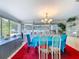 Bright dining room features a vibrant red rug, modern chandelier, and natural light at 7111 Lawnview Ct, Tampa, FL 33615