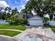 Home exterior features manicured lawn, mature trees, and attached garage in a residential neighborhood at 7111 Lawnview Ct, Tampa, FL 33615