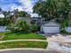 Traditional home featuring an attached two-car garage, green lawn, and mature landscaping at 7111 Lawnview Ct, Tampa, FL 33615
