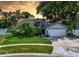 Charming single-story home featuring a well-manicured lawn, mature trees, and a two-car garage at 7111 Lawnview Ct, Tampa, FL 33615