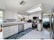 Well-lit kitchen with stainless steel appliances, tile backsplash, and white cabinets at 7111 Lawnview Ct, Tampa, FL 33615
