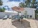 Comfortable patio with dining set, lounge chairs, and shade umbrella near the house at 7111 Lawnview Ct, Tampa, FL 33615