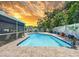 Sparkling in-ground pool with decorative tile surround, lush plants, and a privacy fence at 7111 Lawnview Ct, Tampa, FL 33615
