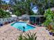 Inviting pool area with tiled patio, lush landscaping, and outdoor seating at 7111 Lawnview Ct, Tampa, FL 33615