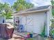 Outdoor shed with double doors, potted plants, and adjacent grilling area at 7111 Lawnview Ct, Tampa, FL 33615