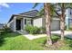 Inviting home exterior with a tidy front yard, dark shutters, and a convenient two-car garage at 7211 Ozello Trail Ave, Sun City Center, FL 33573